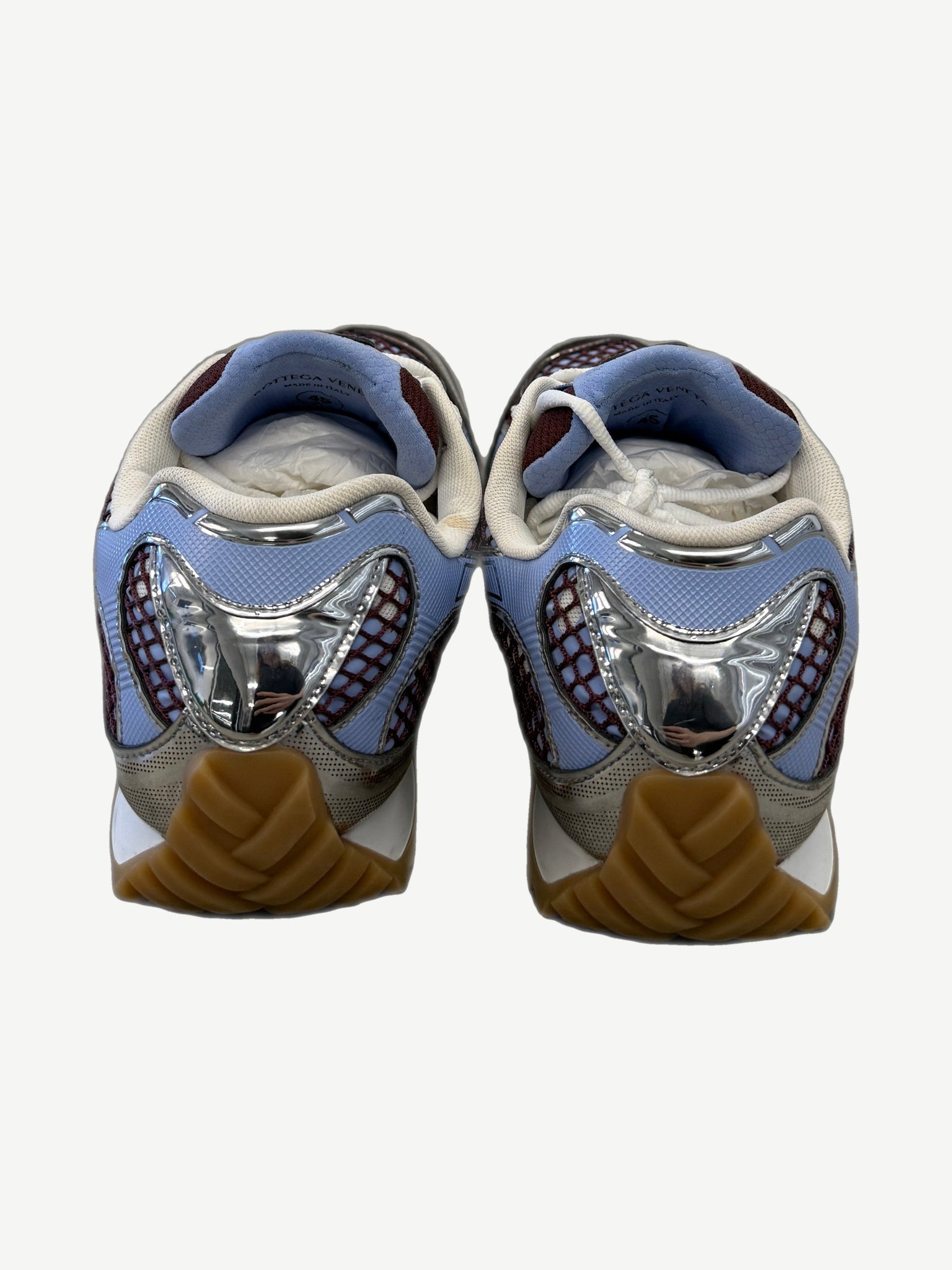 Bottega Veneta Orbit sneakers heel view with chrome silver heel cup and chunky gum rubber sole.