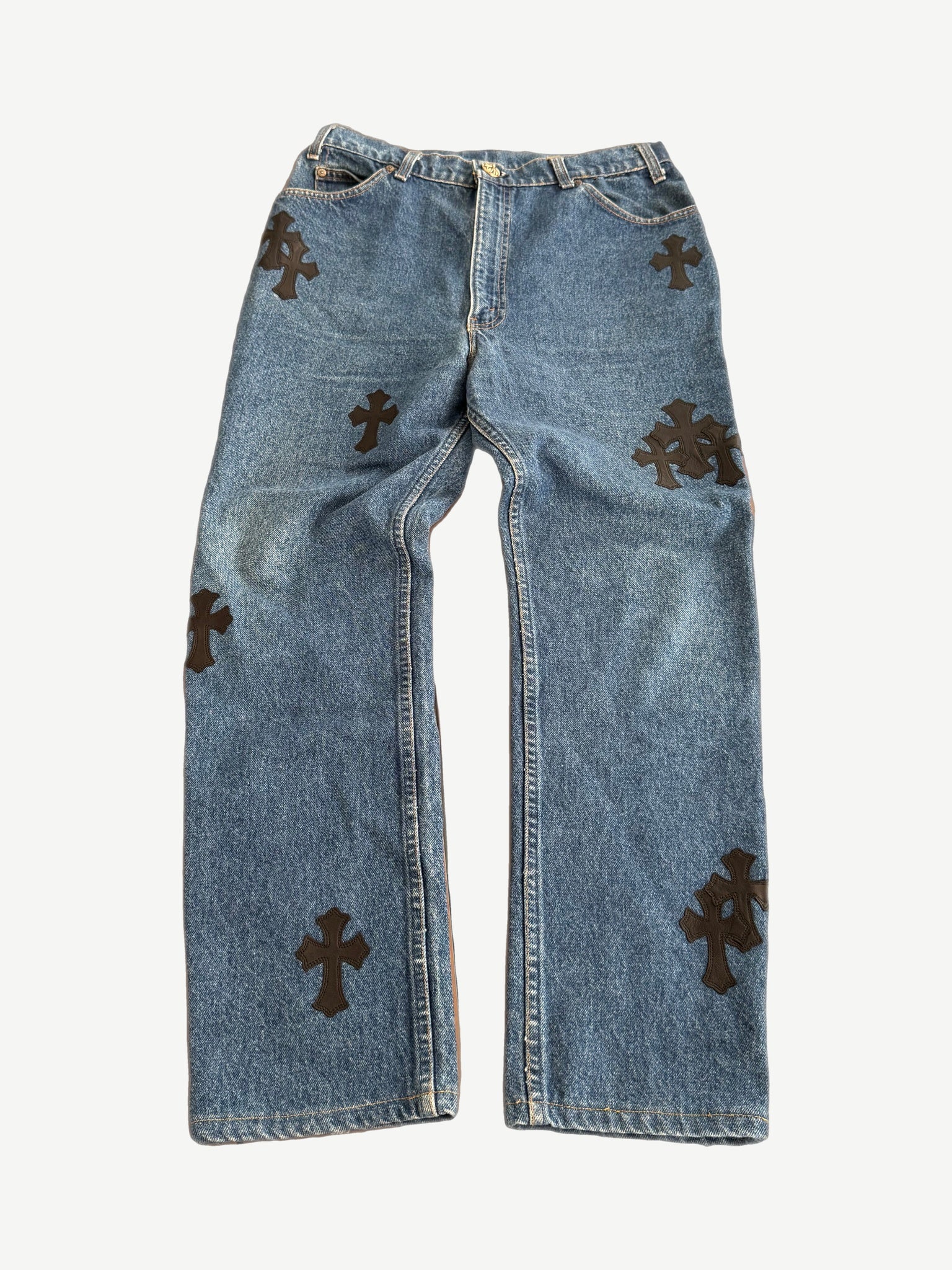 Chrome Hearts x Levis 517 dark wash jeans front view with custom black leather cross patch on the front pocket