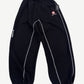 Raspberry Hills Berry Med black sweatpants with red Swiss cross logo patch, contrast white overlock stitching and cinched cuffs.