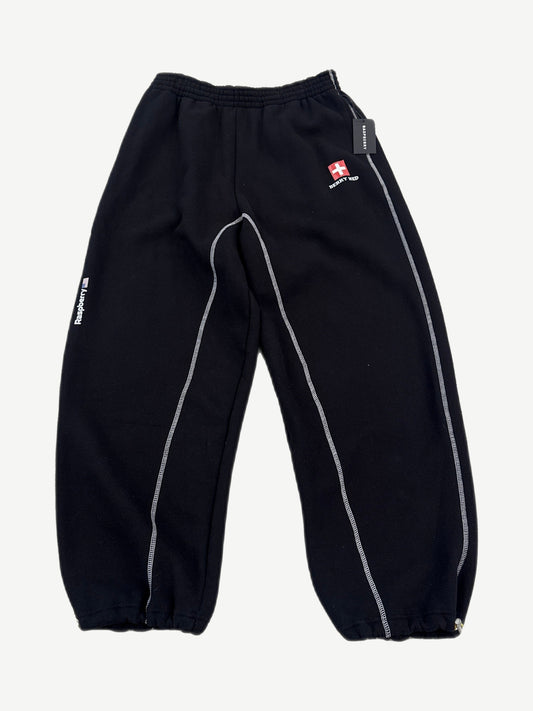 Raspberry Hills Berry Med black sweatpants with red Swiss cross logo patch, contrast white overlock stitching and cinched cuffs.