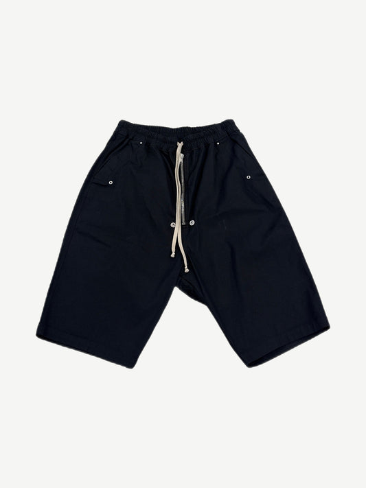 Rick Owens black Bela drop-crotch cargo shorts with drawstring waist and side snap pockets, front view.