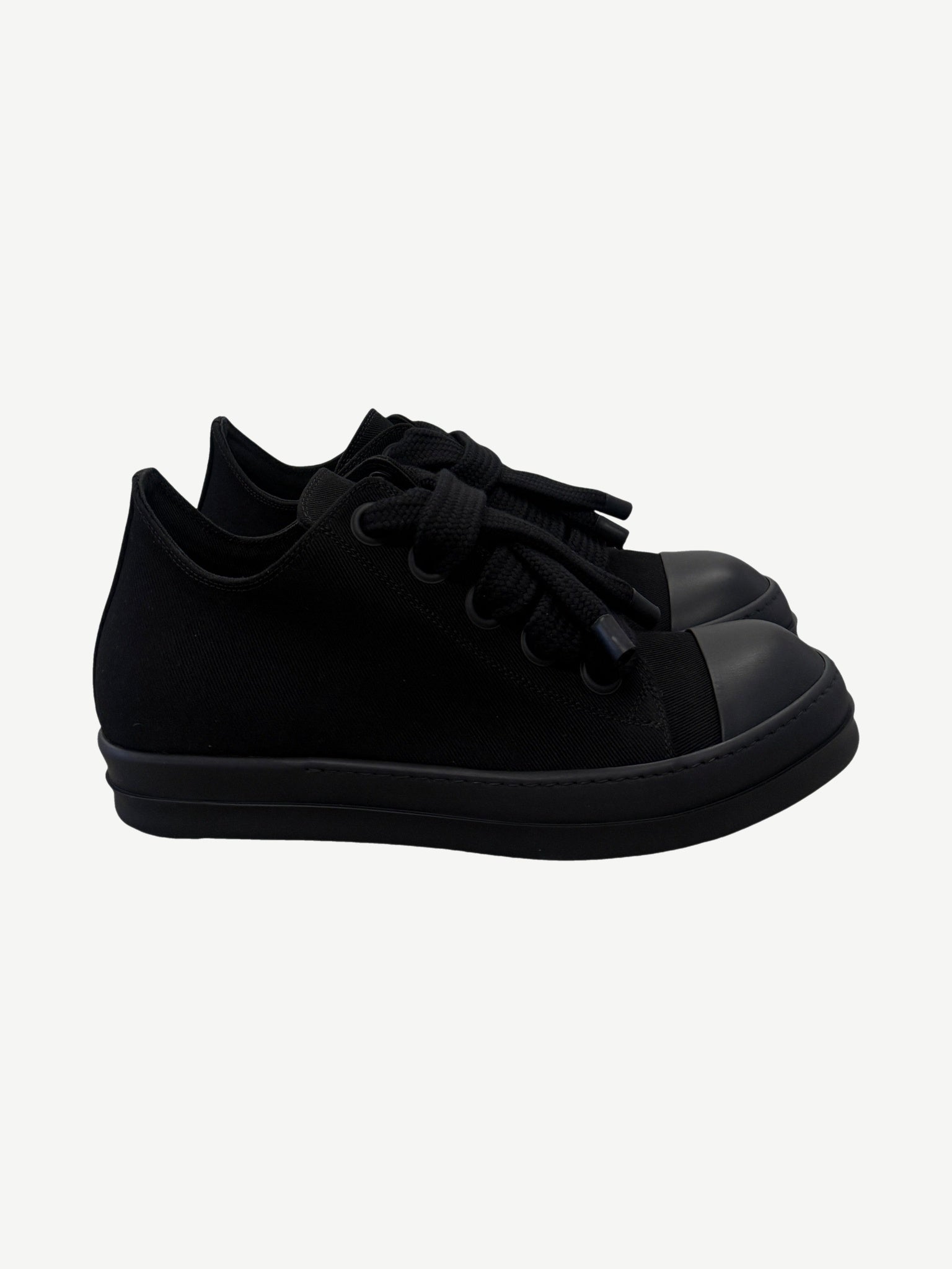 Rick Owens DRKSHDW triple black low top sneakers side view with jumbo laces and rubber cap toe