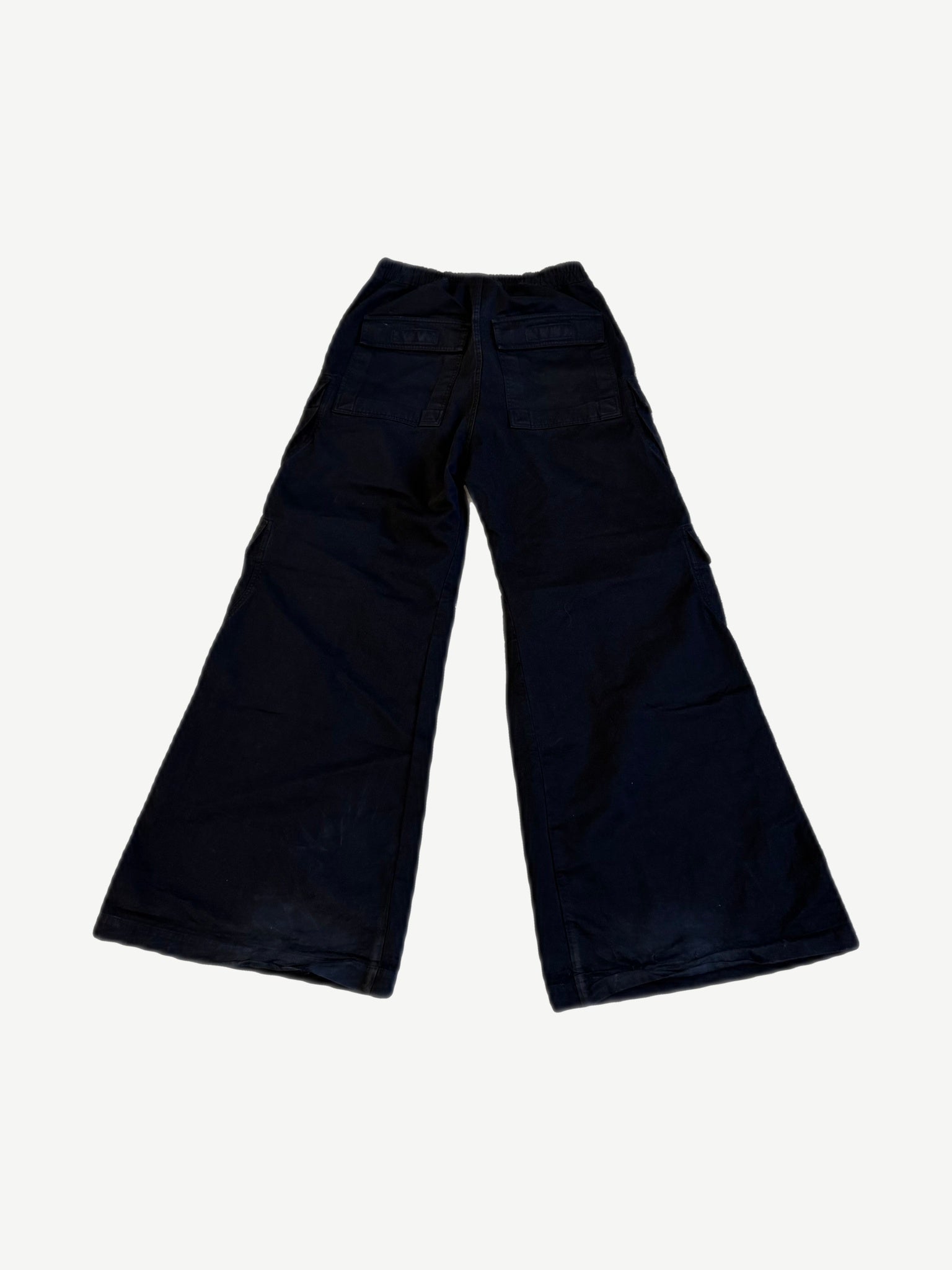 Back of Rick Owens Bela dark canvas cargo pants showing wide flared leg and welt rear pocket detail.
