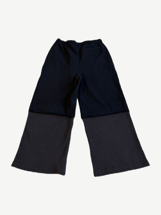 Back view of Satoshi Nakamoto black sweatpants with gray waffle thermal layered lower legs and elastic waist