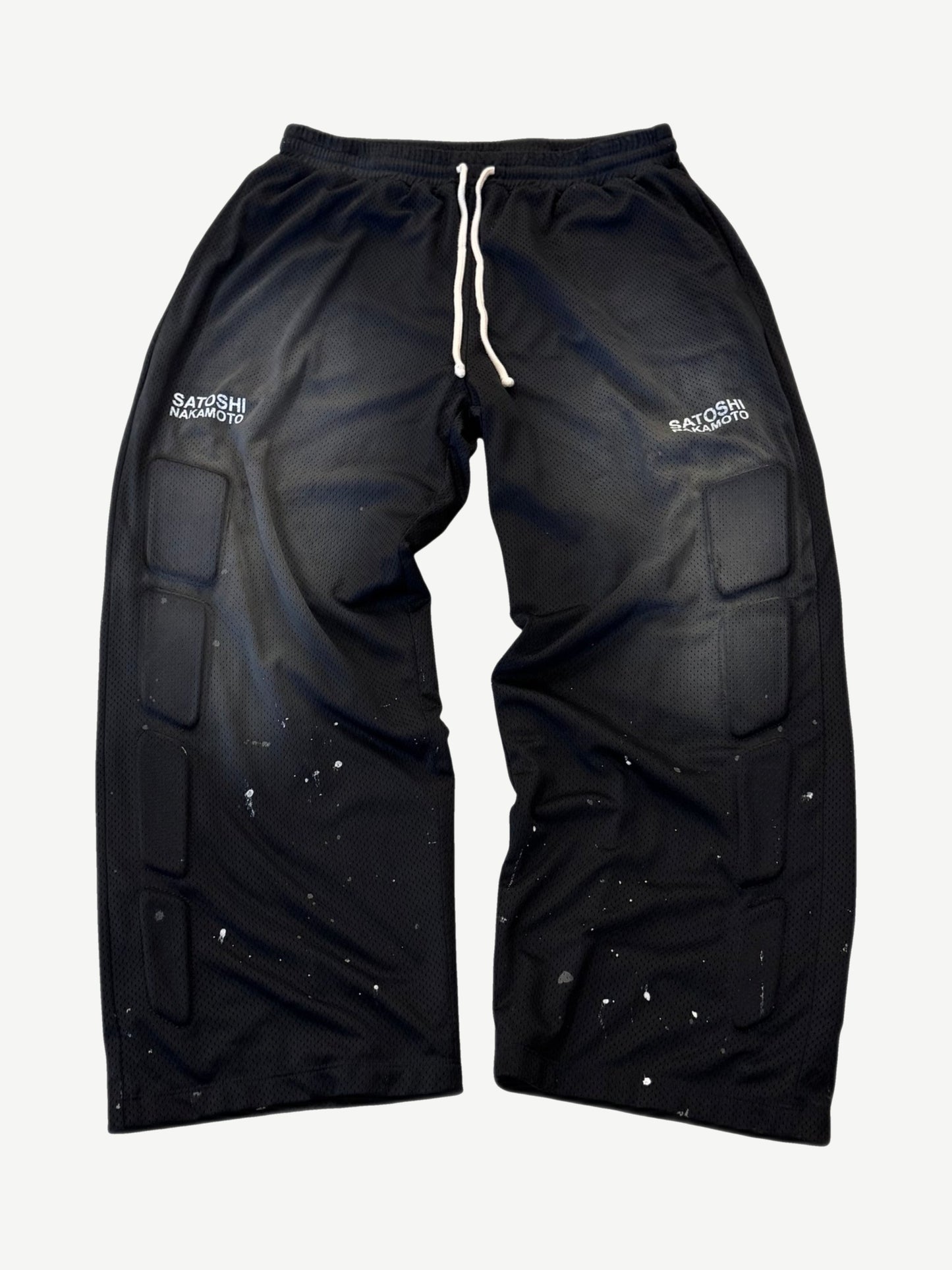 Satoshi Nakamoto black mesh moto sweatpants front with padded knee armor panels and white paint splatter