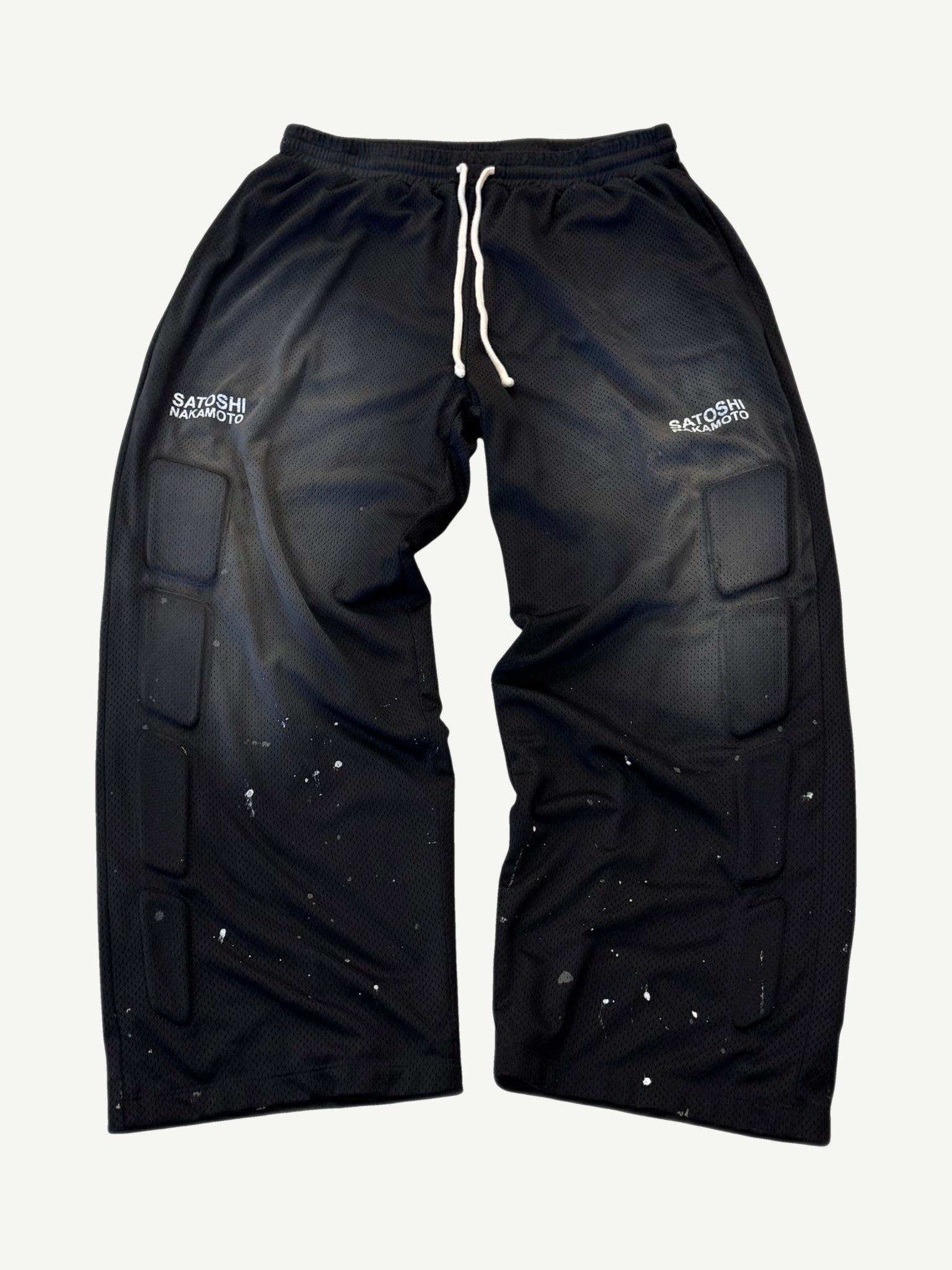 Satoshi Nakamoto black mesh moto sweatpants front with padded knee armor panels and white paint splatter