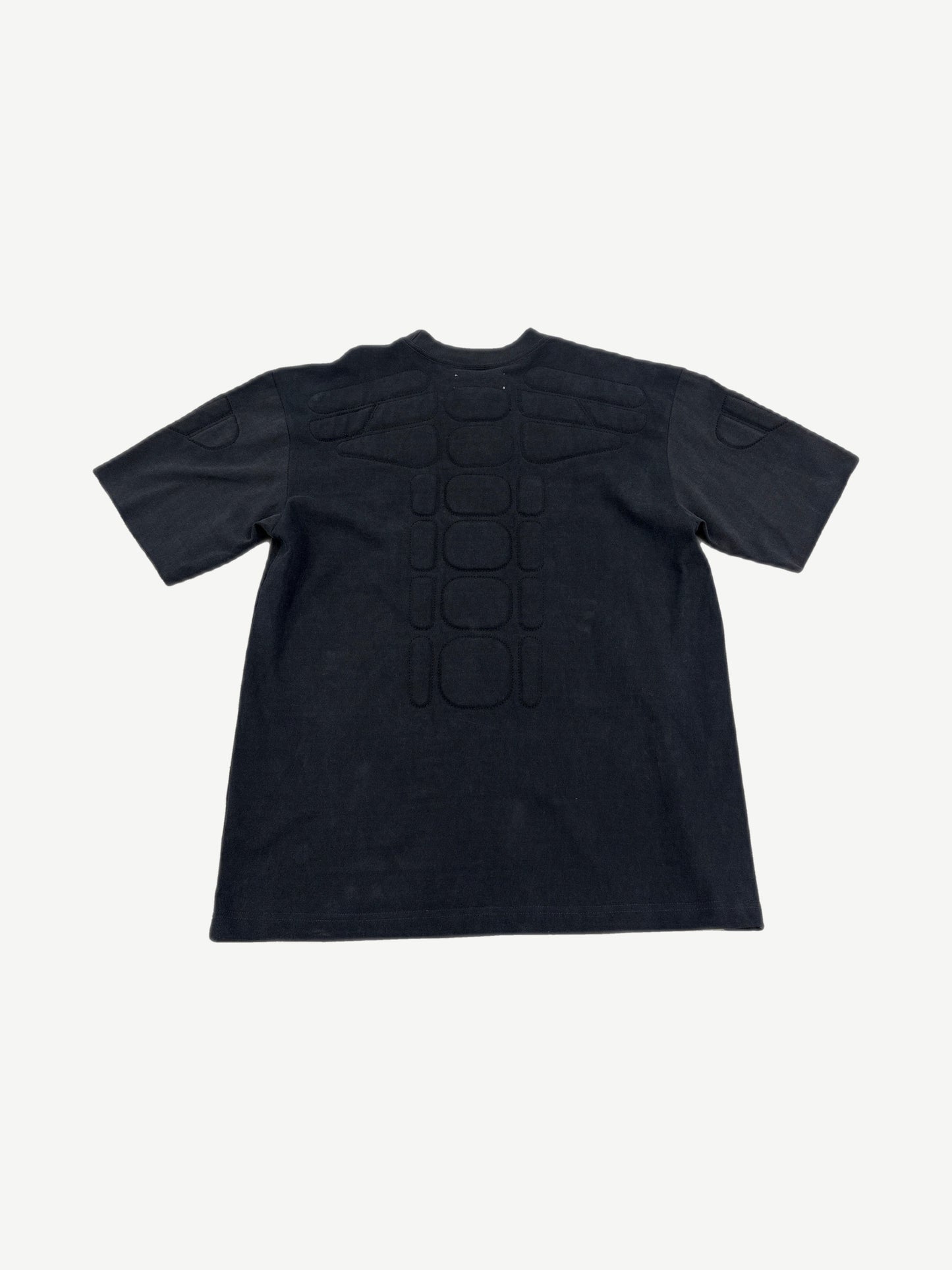 Satoshi Nakamoto black moto tee back with padded spine ribs and shoulder armor panels.