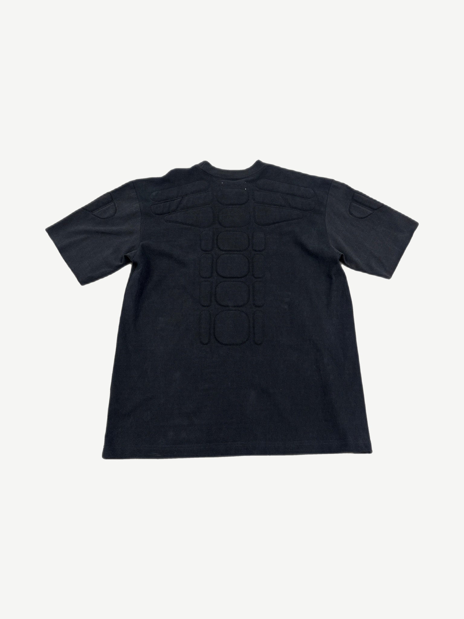 Satoshi Nakamoto black moto tee back with padded spine ribs and shoulder armor panels.
