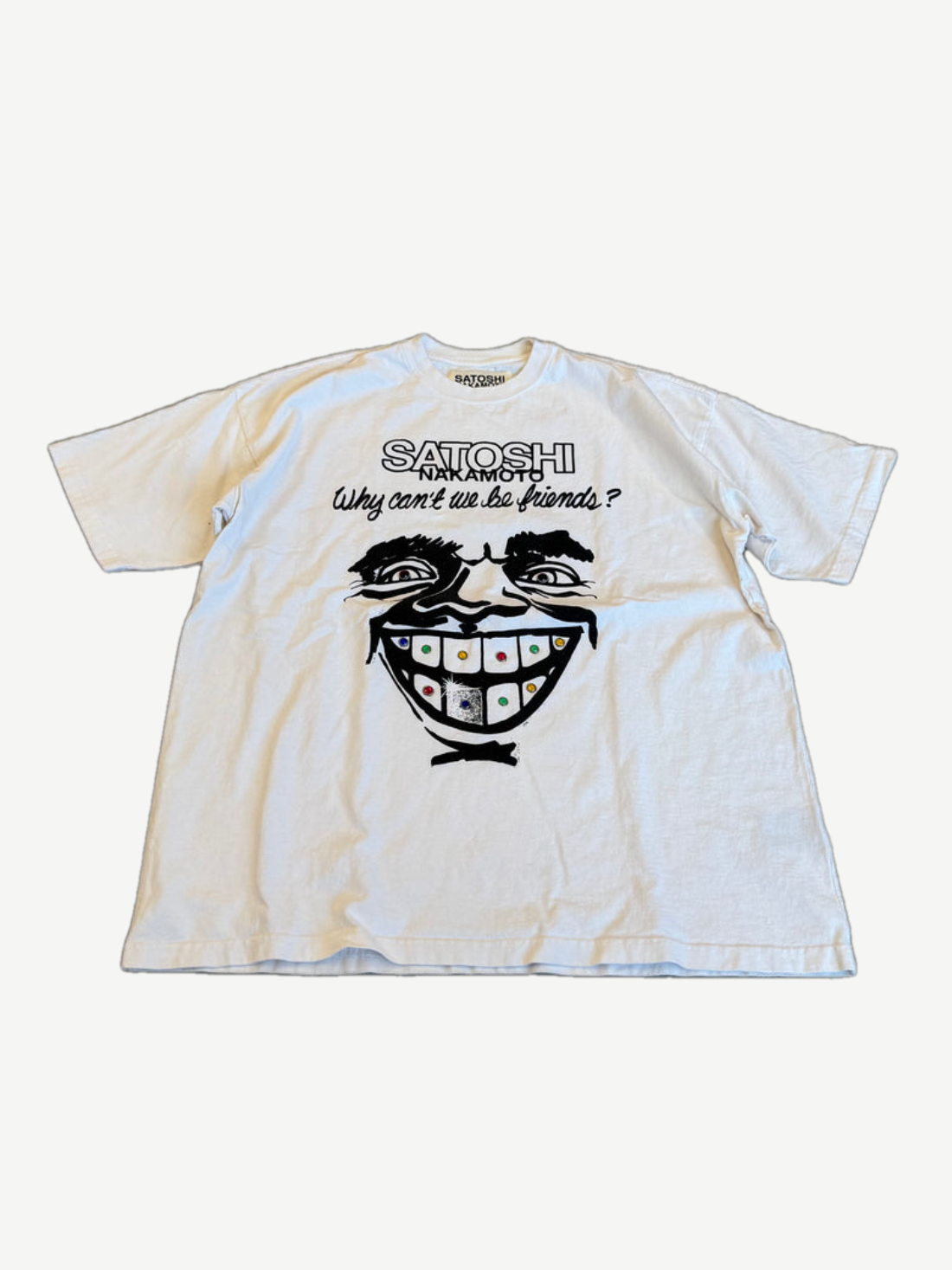 Satoshi Nakamoto Why Can't We Be Friends tee in white with grinning face graphic and jeweled grill print.