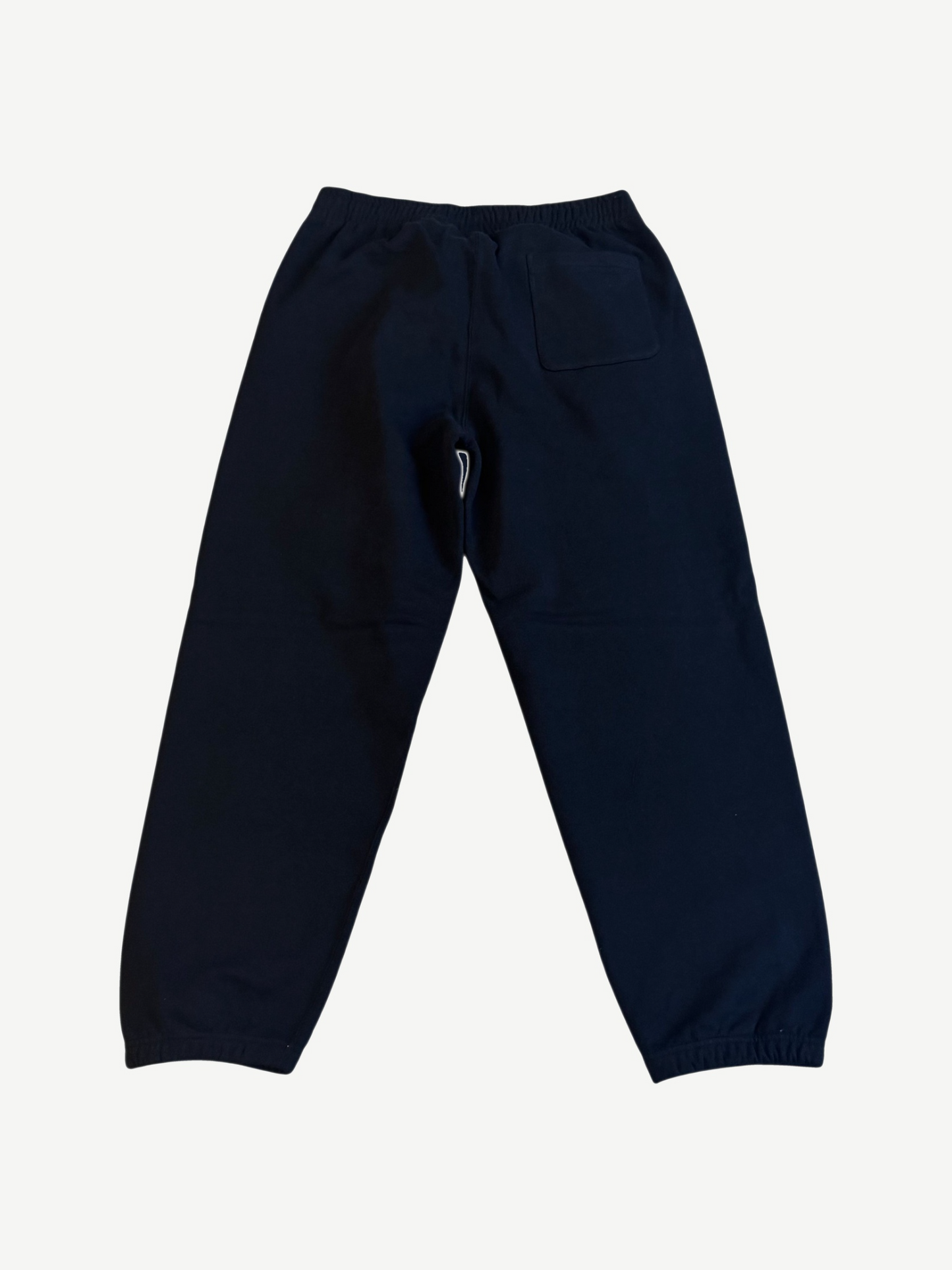 Supreme black satin sweatpants back view with patch pocket, elastic cuffs and clean tonal black fleece body