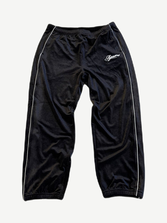 Supreme black velour mesh track pants with white piping side stripes and script Supreme thigh logo.