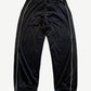 Supreme black velour mesh track pants back view with white side piping and elastic ankle cuffs.