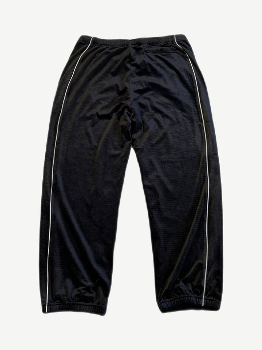 Supreme black velour mesh track pants back view with white side piping and elastic ankle cuffs.
