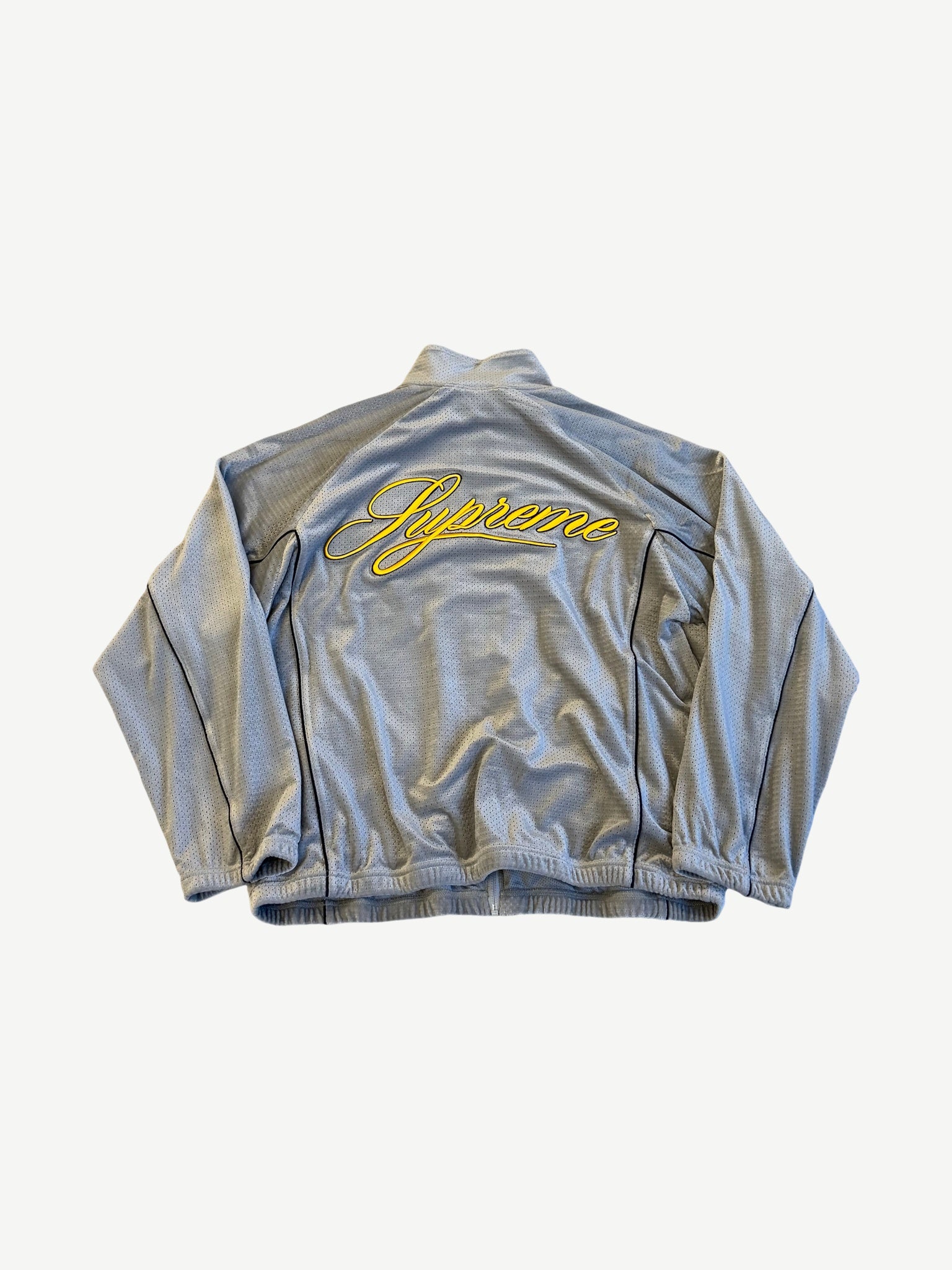 Supreme grey velour track jacket back view with yellow embroidered Supreme script across panel.