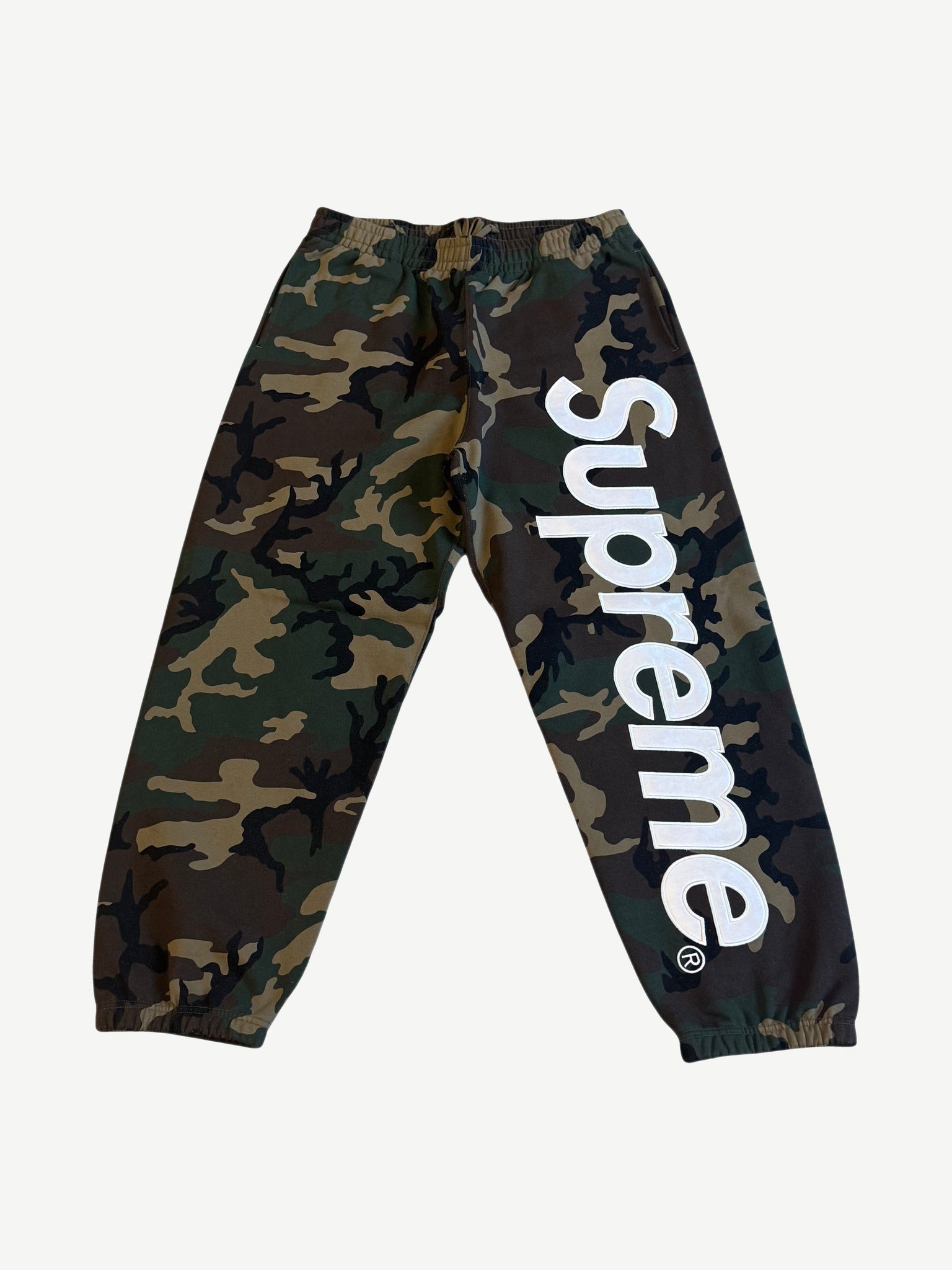 Supreme woodland camo sweatpants with large white satin applique Supreme logo down the leg