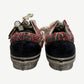 Heel view of Vans Old Skool sneakers showing navy sequin back panels and red tweed collar detail