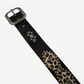 Vintage studded leather belt detail showing chrome buckle, pyramid studs and leopard cowhide patches.