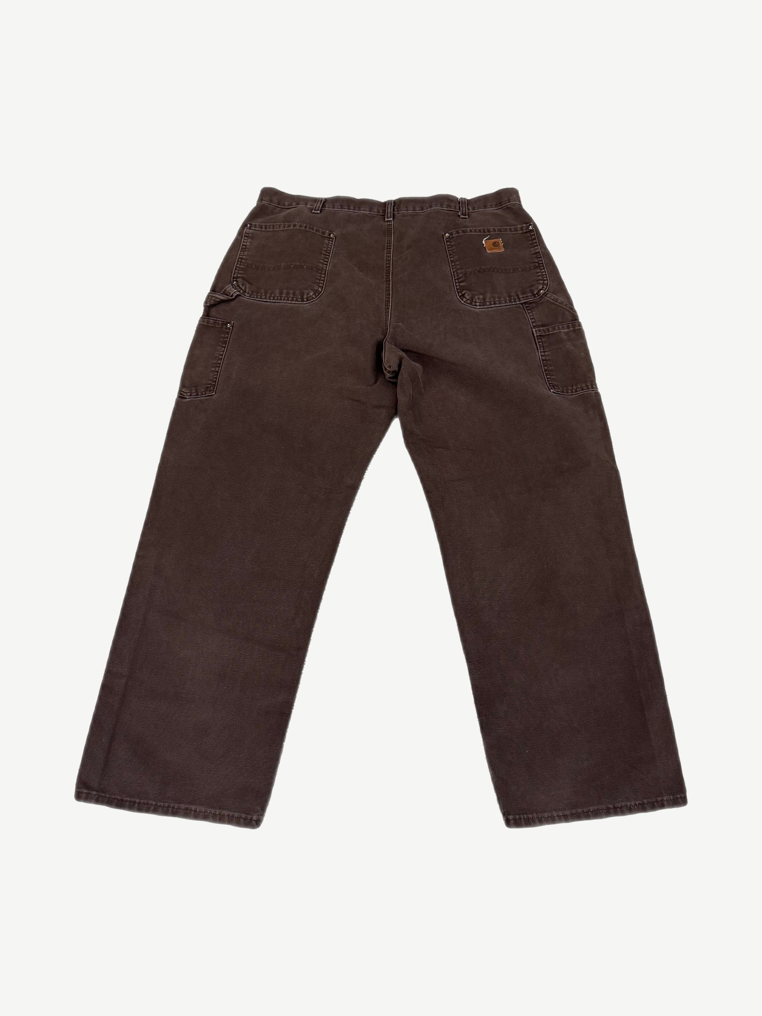 Vintage Carhartt faded brown canvas double-knee work pants with utility pockets and leather waist tab.