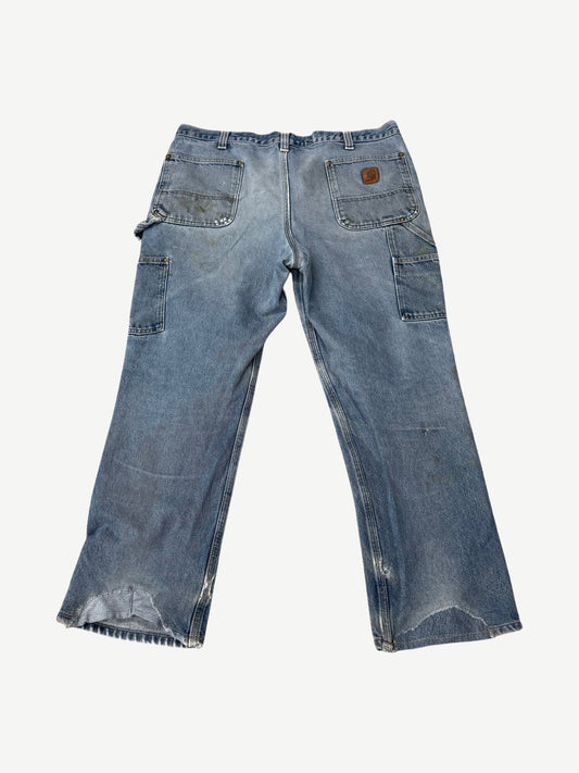 Vintage Carhartt faded blue carpenter pants back view with utility pockets and worn rugged fabric.