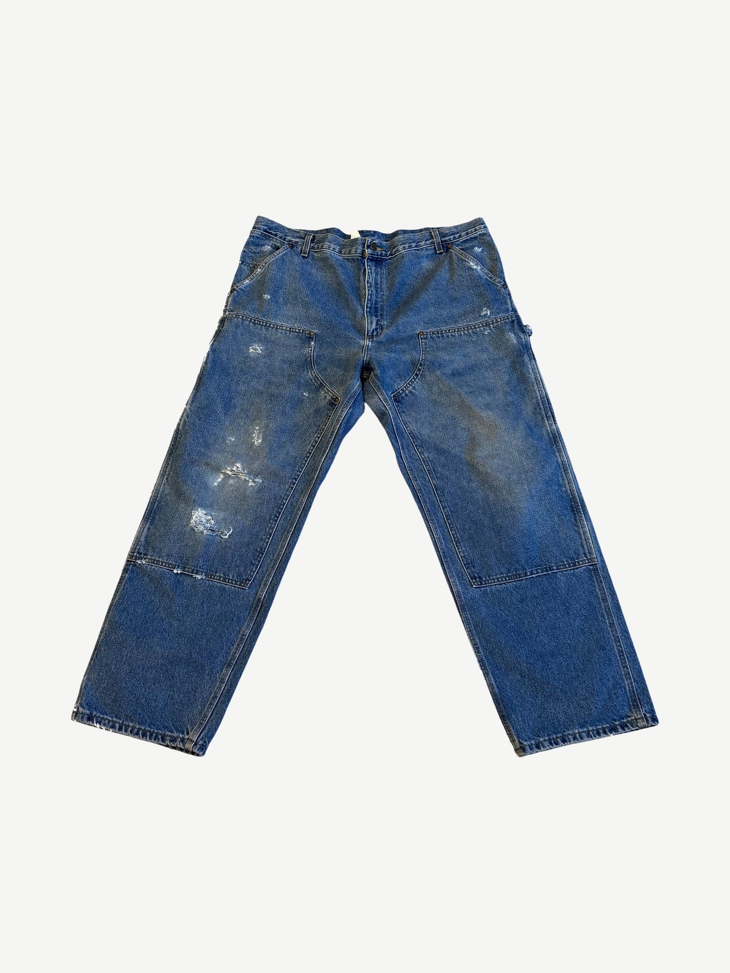 Vintage Carhartt medium wash denim double knee carpenter pants with paint splatter and utility hammer loop.