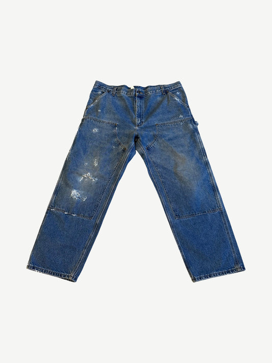 Vintage Carhartt medium wash denim double knee carpenter pants with paint splatter and utility hammer loop.