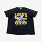 Vintage Lord's Gym black tee front with yellow varsity Lord's Gym text, Jesus bench-pressing cross Bench Press This graphic.