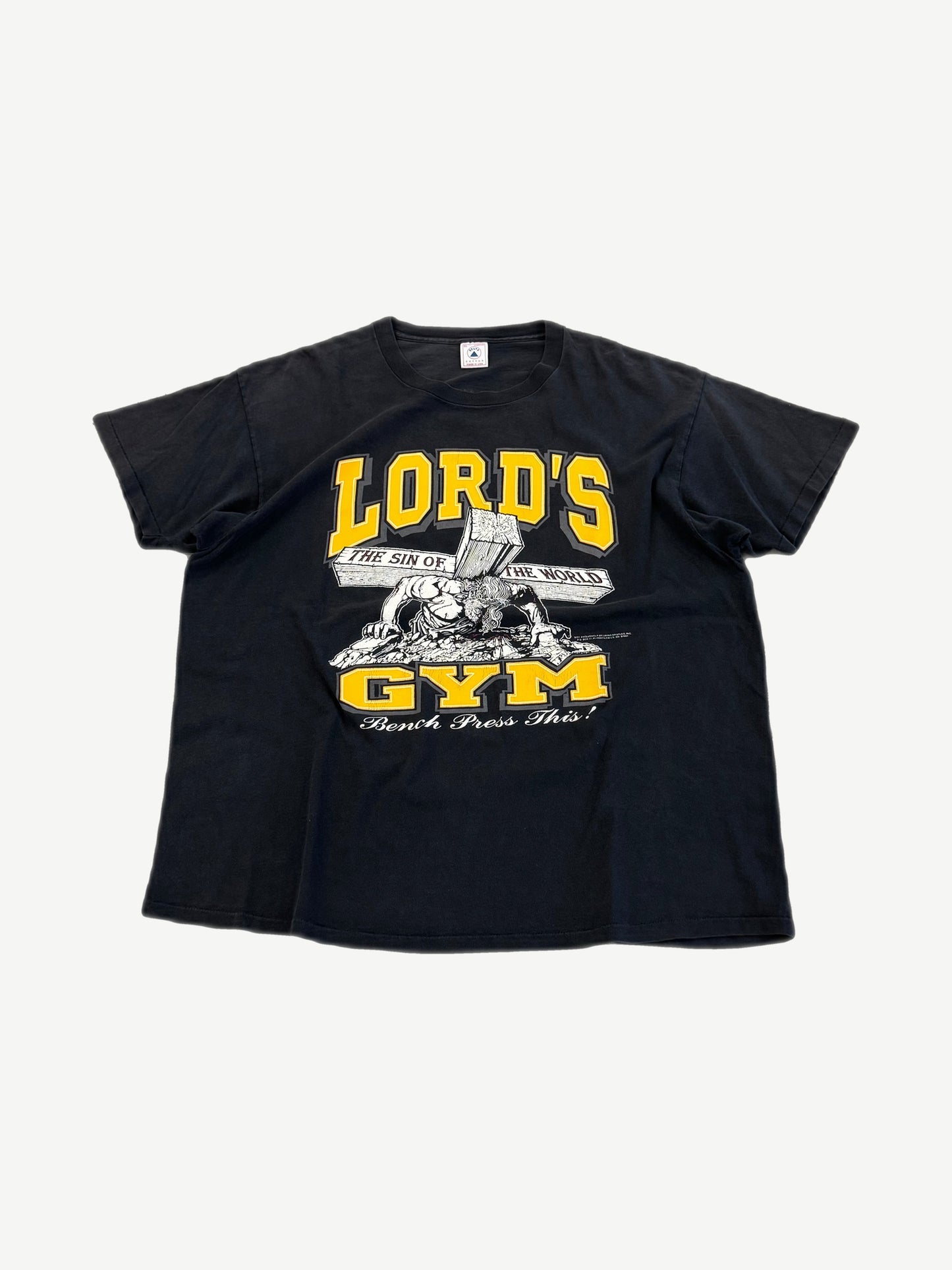 Vintage Lord's Gym black tee front with yellow varsity Lord's Gym text, Jesus bench-pressing cross Bench Press This graphic.