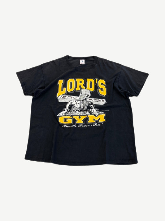 Vintage Lord's Gym black tee front with yellow varsity Lord's Gym text, Jesus bench-pressing cross Bench Press This graphic.