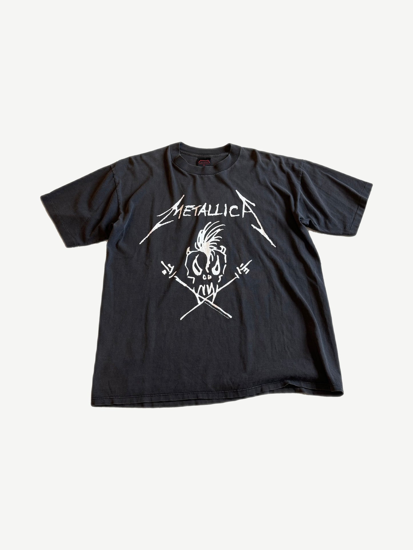 Vintage Metallica Nowhere Else to Roam black tee with white skull and crossed drumstick scribble logo.
