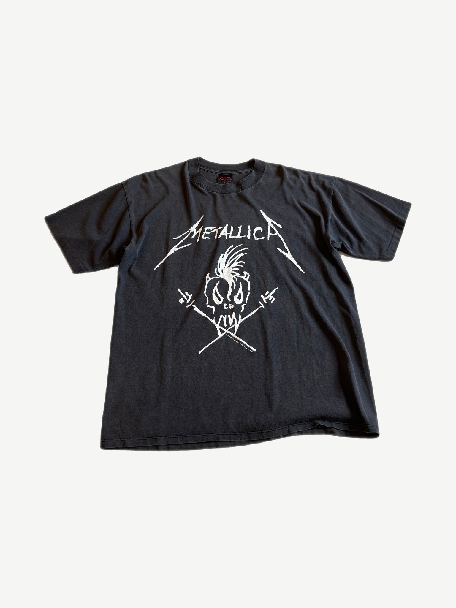 Vintage Metallica Nowhere Else to Roam black tee with white skull and crossed drumstick scribble logo.