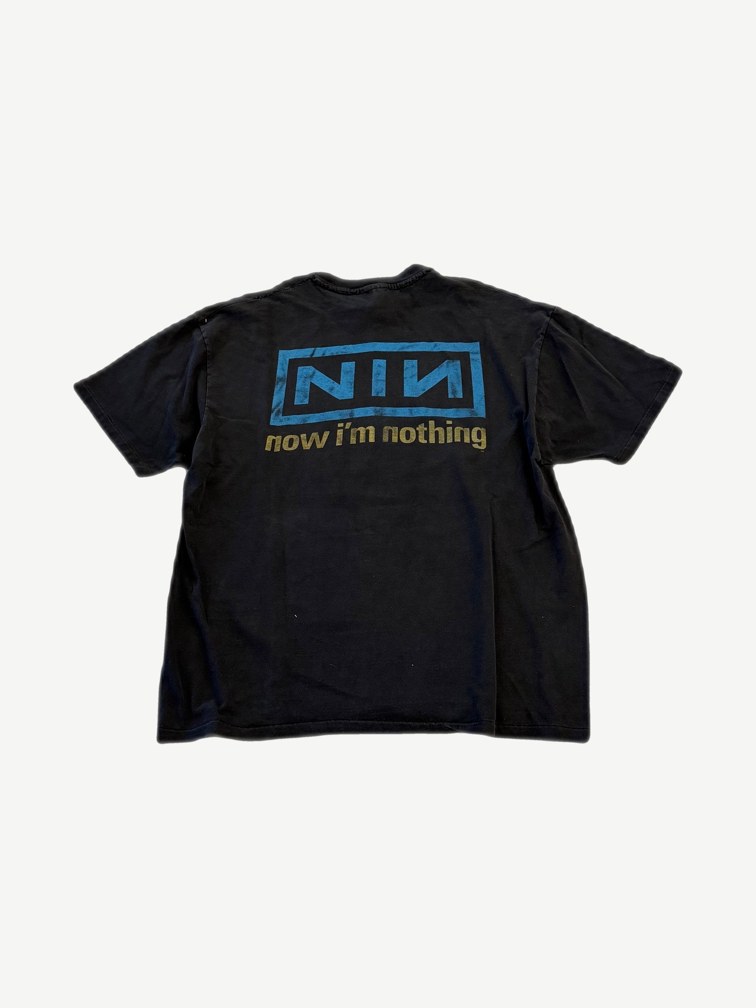 Back of vintage Nine Inch Nails tee with boxed NIN logo and Now I'm Nothing text in blue and gold.