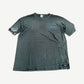 Vintage Subaru faded black tee with small blue chest logo and safety pin detail at sleeve.