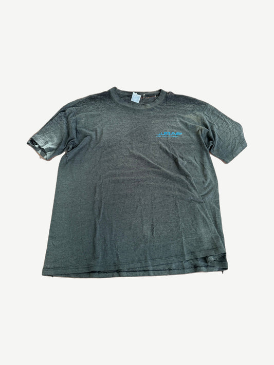 Vintage Subaru faded black tee with small blue chest logo and safety pin detail at sleeve.