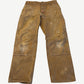 Vintage tan Carhartt double knee carpenter pants front view, heavily worn canvas with paint splatter and knee blowout.