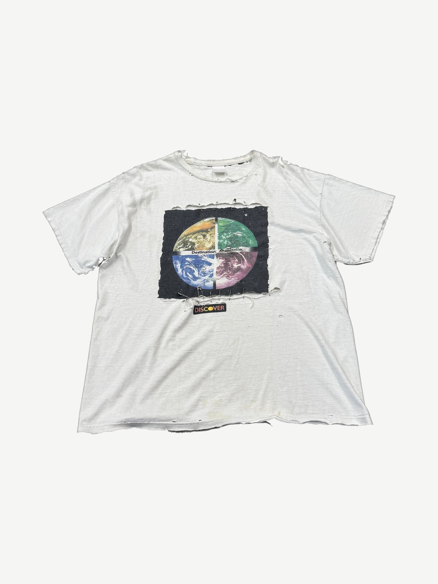 Vintage white tee with distressed holes and Destination Anywhere safety-pinned patch featuring quartered earth graphic