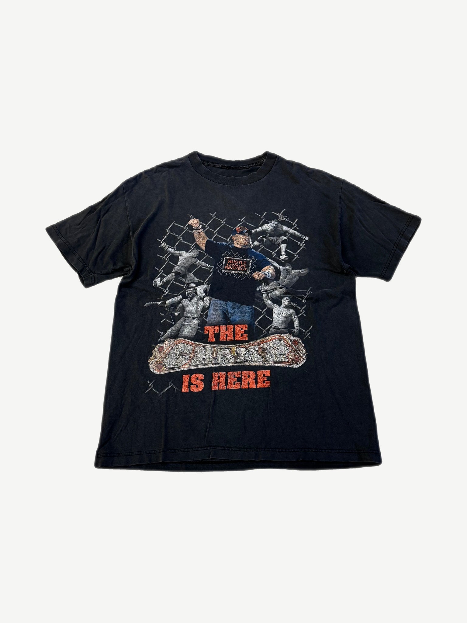 Vintage WWE John Cena The Champ is Here black tee with orange caged ring graphic and wrestlers print, front